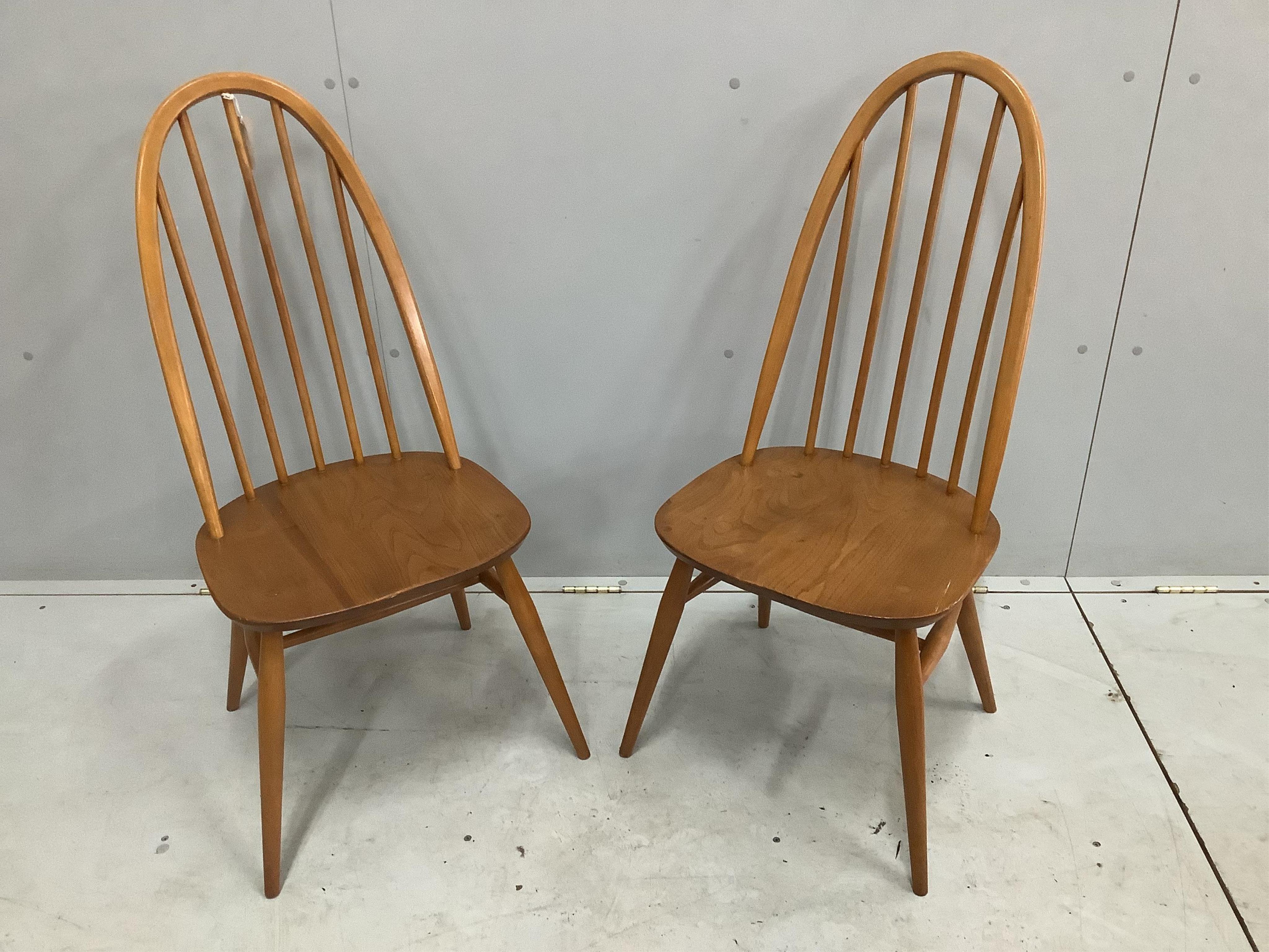 A pair of mid century Ercol elm and beech comb back dining chairs, height 96cm. Condition - fair to good, one with some damage to the top rail